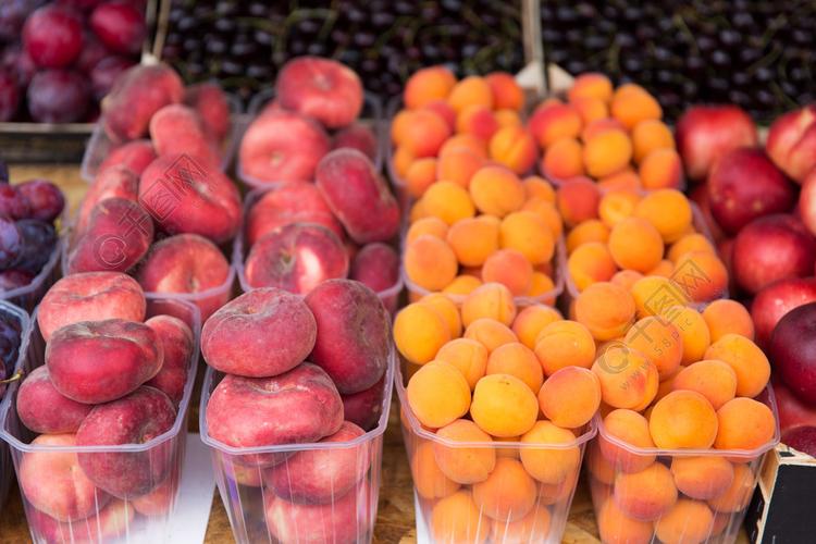 销售收获食品水果和农业的概念在街头市场的塑料盒里的扁平桃子和杏子